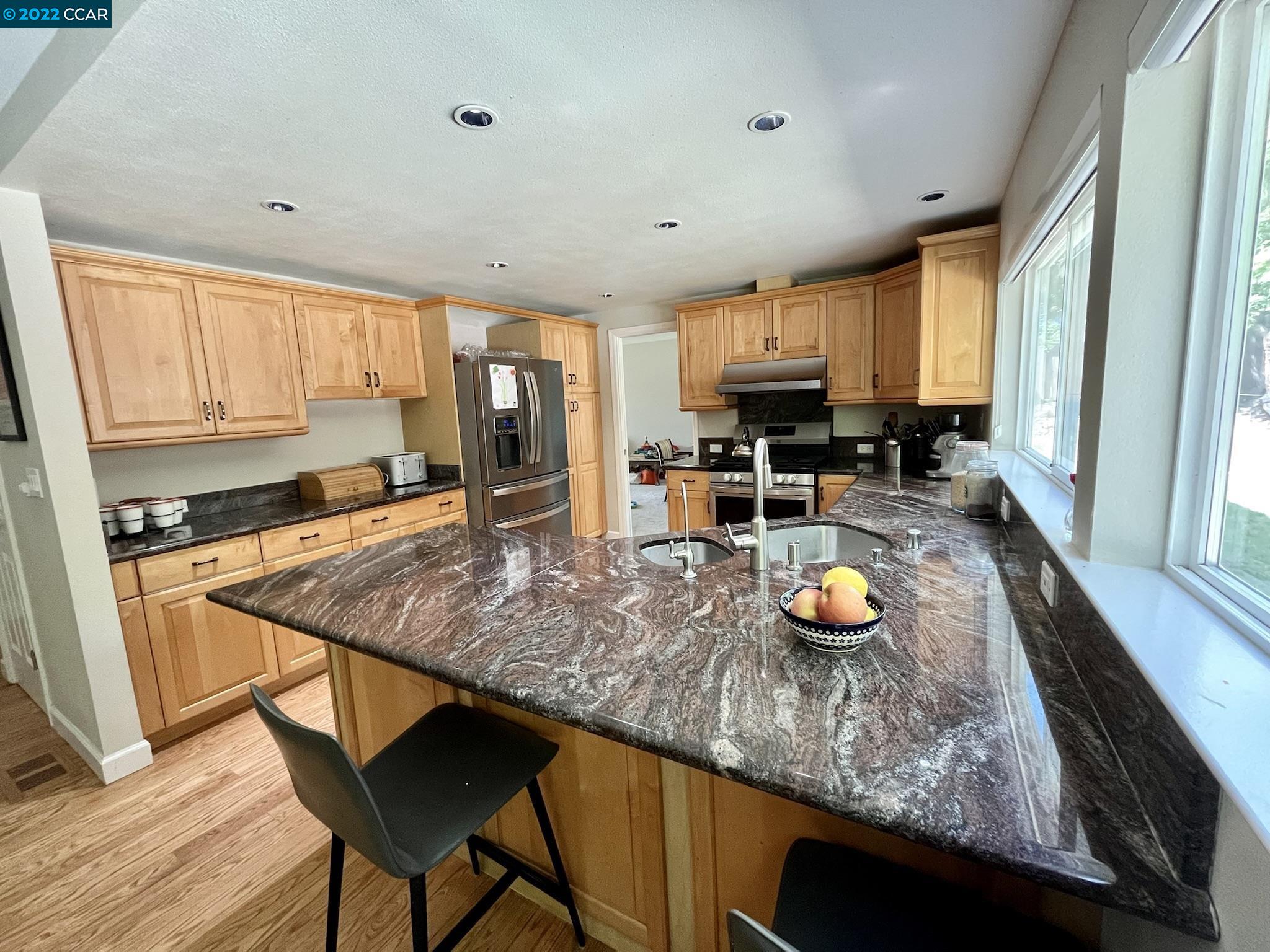 4387 Fallbrook Road Concord, CA 94521 - Photo 4 of 26 a kitchen with a stove a sink and a wooden cabinets