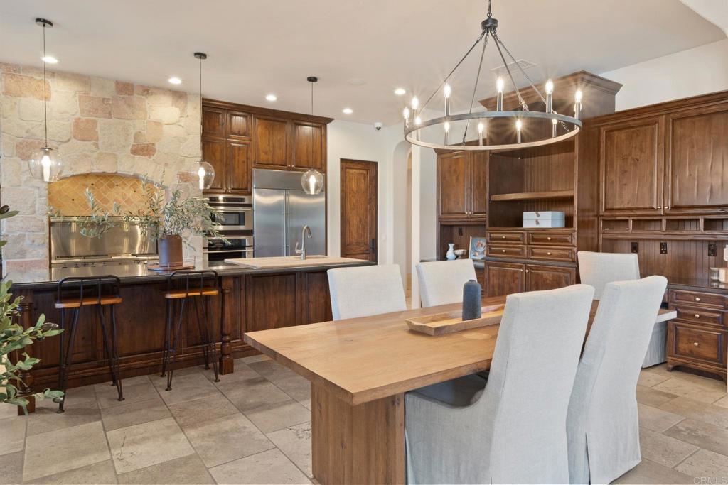 2908 Gate 5 Place Chula Vista, CA 91914 - Photo 18 of 63 a kitchen with stainless steel appliances kitchen island granite countertop a table chairs and a refrigerator