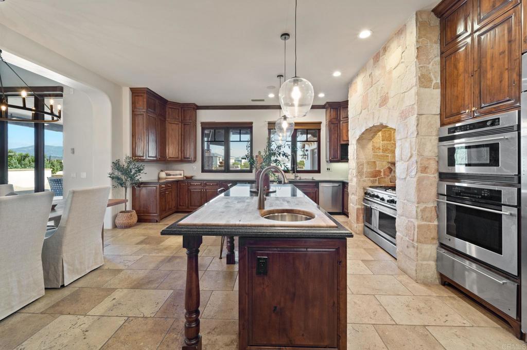 2908 Gate 5 Place Chula Vista, CA 91914 - Photo 21 of 63 a kitchen with stainless steel appliances granite countertop a sink a stove and a wooden floors