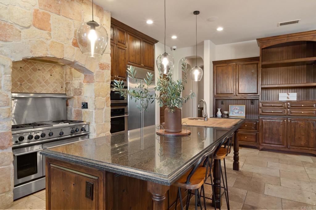 2908 Gate 5 Place Chula Vista, CA 91914 - Photo 27 of 63 a kitchen with kitchen island granite countertop a stove a sink and a refrigerator