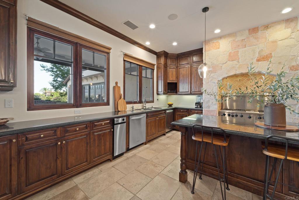 2908 Gate 5 Place Chula Vista, CA 91914 - Photo 28 of 63 a kitchen with kitchen island granite countertop wooden cabinets a counter top space and stainless steel appliances