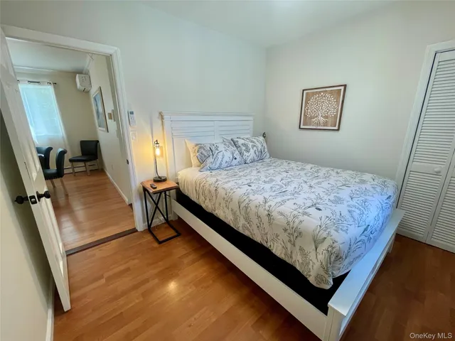 a bedroom with a bed window and a wooden floor