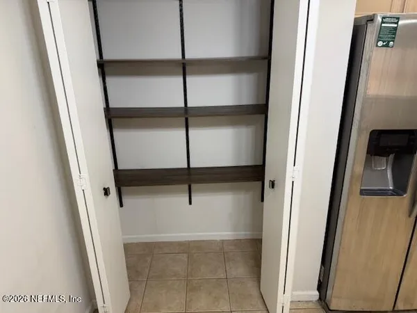 a view of walk in closet with empty racks