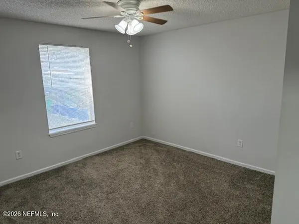 an empty room with a chandelier fan