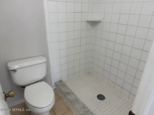 a bathroom with a toilet and a shower