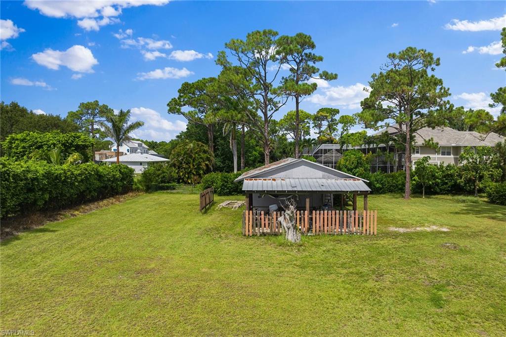 124 Eugenia Drive Naples, FL 34108 - Photo 17 of 20 a view of a swimming pool with a table and chairs under an umbrella