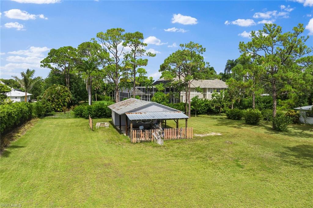 124 Eugenia Drive Naples, FL 34108 - Photo 8 of 20 a view of a swimming pool with a table and chairs under an umbrella