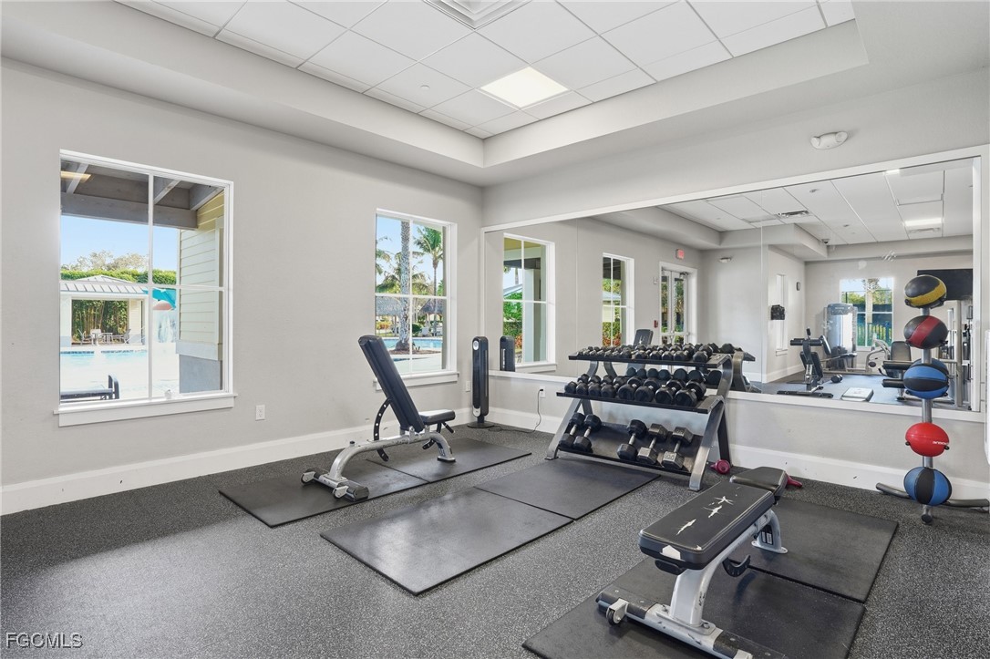 2662 Scarlet Way Naples, FL 34120 - Photo 36 of 47 a living room with furniture a dining table and a floor to ceiling window