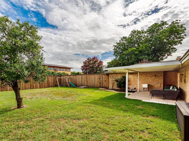 a view of a house with a yard and sitting area