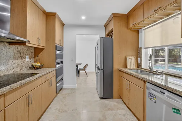 a kitchen with stainless steel appliances granite countertop a refrigerator and a sink