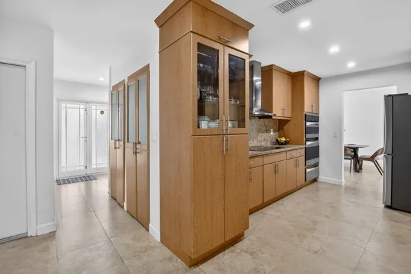 a kitchen with kitchen island granite countertop a refrigerator and cabinets