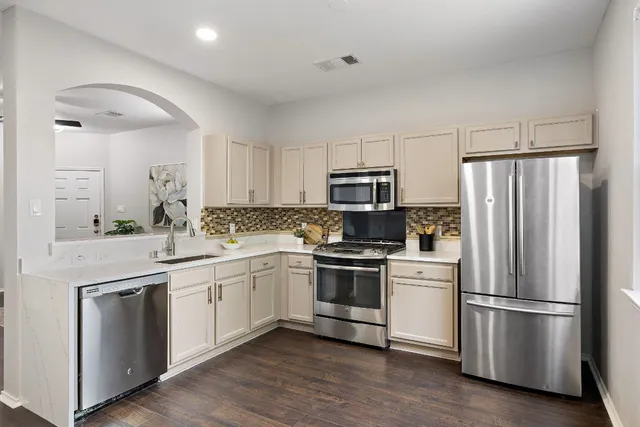 a kitchen with white cabinets and stainless steel appliances