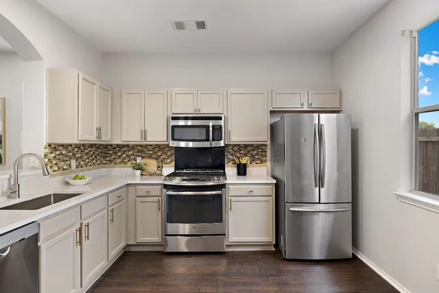 a kitchen with white cabinets and white stainless steel appliances