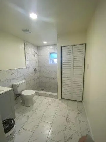a bathroom with a toilet and a shower