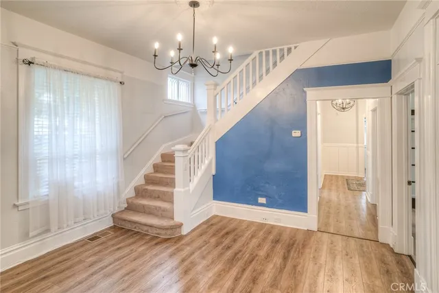 a view of a hallway with wooden floor and staircase