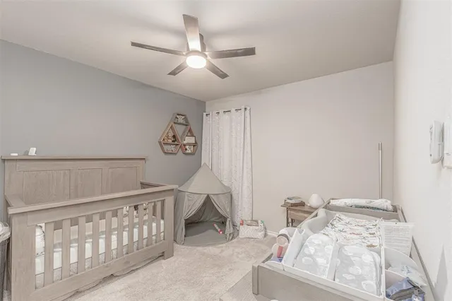 a bedroom with furniture and a chandelier fan