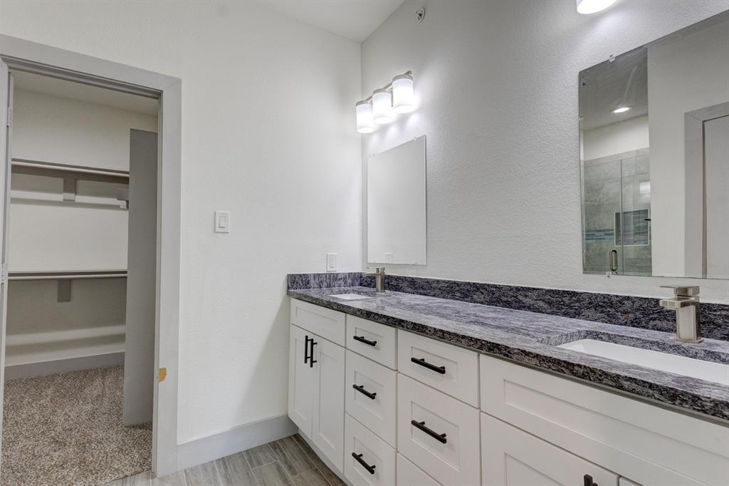 6043 Rivendell Drive Frisco, TX 75035 - Photo 22 of 38 a bathroom with a granite countertop sink and a mirror