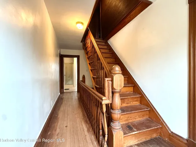 a view of staircase with wooden floor and white walls