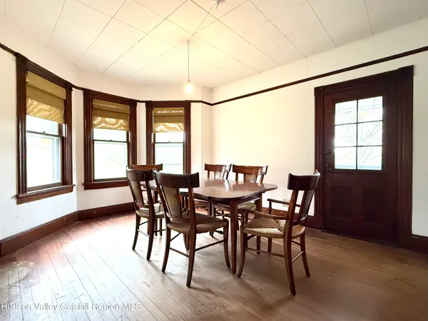 a view of a dining room with furniture a chandelier and wooden floor