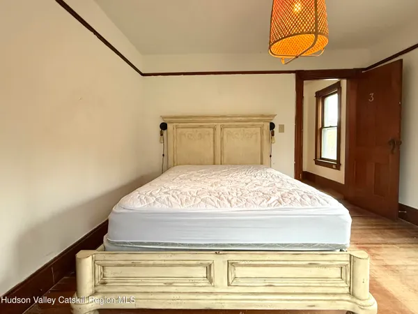 a bedroom with a bed and lamp with the wooden floor