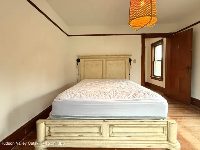 a bedroom with a bed and lamp with the wooden floor