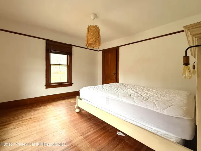 a bed sitting in a bedroom next to a window