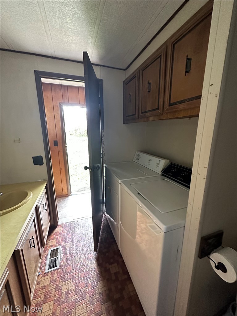 7443 Spillway Road Lisbon, OH 44432 - Photo 16 of 19 Laundry room featuring sink, a textured ceiling, and separate washer and dryer