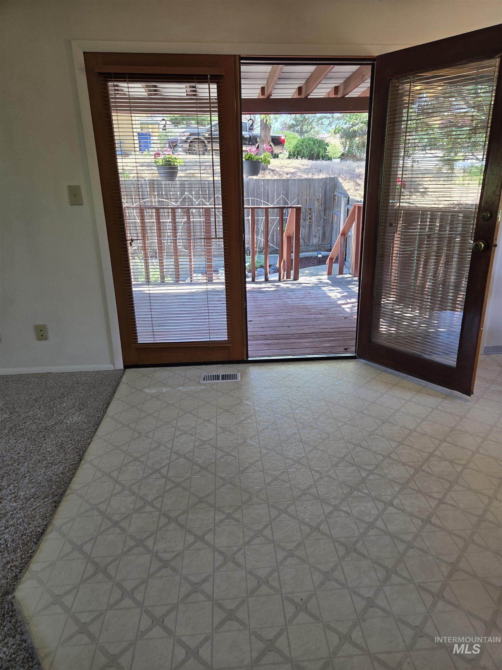 12050 West Hidden Valley Rim Road Boise, ID 83709 - Photo 6 of 39 Sliding glass patio door with wood-finish frames opening to an outdoor deck