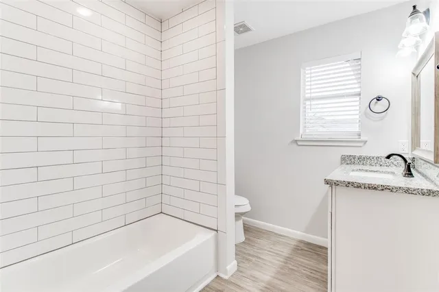 a bathroom with a granite countertop bathtub and sink