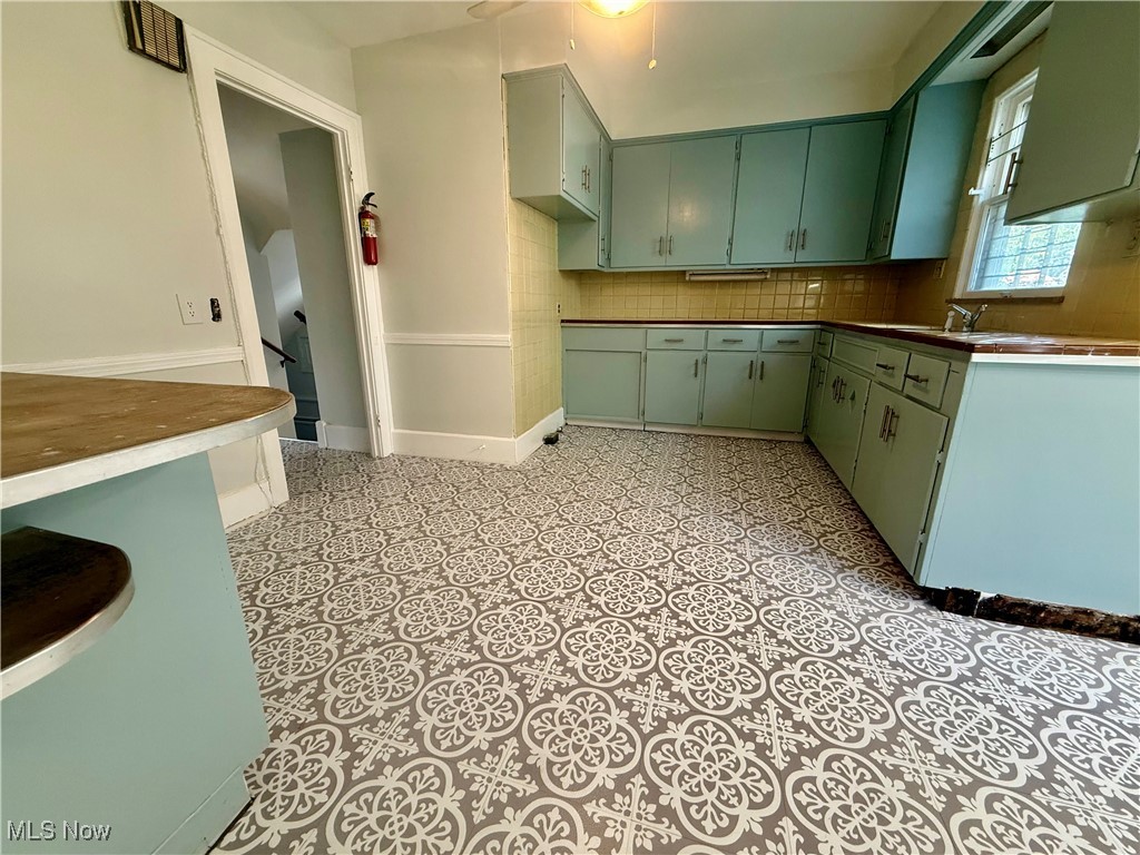 1979 Staunton Road Cleveland, OH 44118 - Photo 6 of 37 Kitchen featuring backsplash and green cabinets