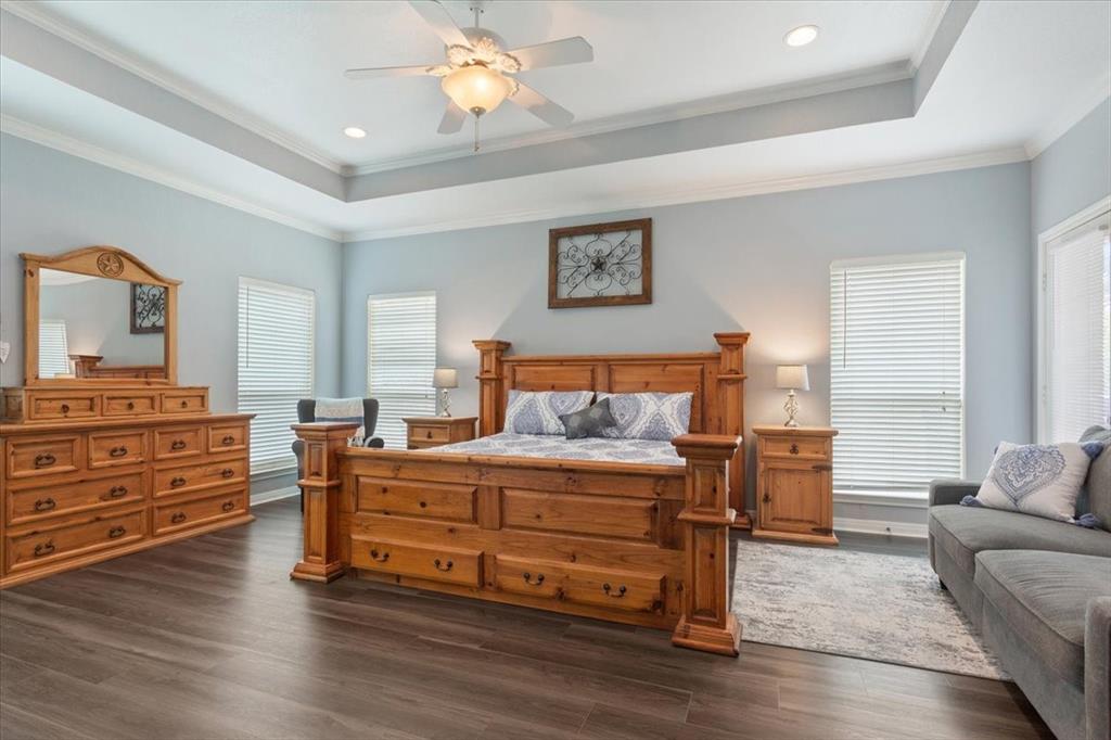 111 Spring Creek Street Waco, TX 76705 - Photo 19 of 40 Tray ceiling with recessed lighting and a ceiling fan, wood-finish flooring, and multiple windows with blinds