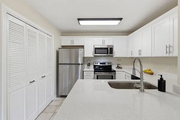a kitchen with stainless steel appliances a refrigerator a sink a stove a microwave and cabinets