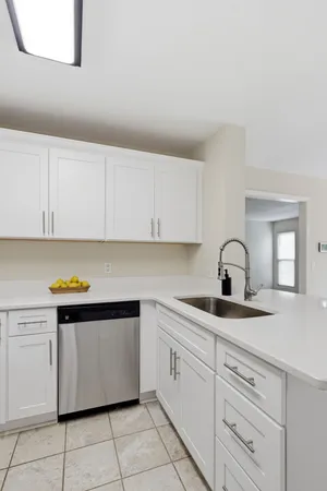 a kitchen with white cabinets appliances and sink