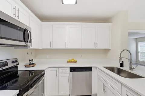 a kitchen with stainless steel appliances granite countertop a sink stove top oven and cabinets