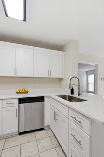 a kitchen with white cabinets appliances and sink