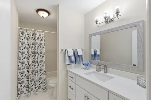 a bathroom with a sink vanity granite and a mirror