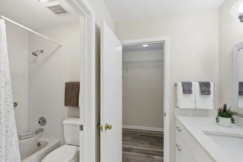 a bathroom with a granite countertop sink toilet and shower