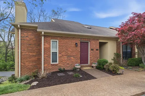 front view of a brick house with a yard