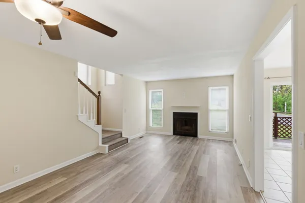 a view of a livingroom with wooden floor a fireplace and windows
