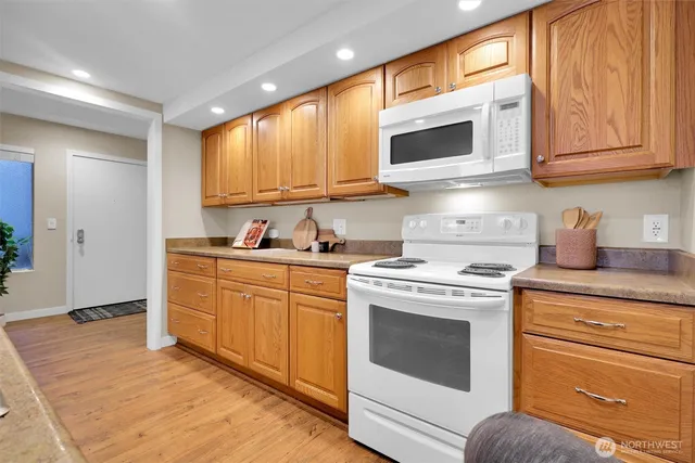 a kitchen with stainless steel appliances granite countertop a stove a sink and a microwave
