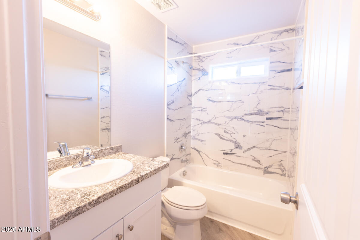 24638 East Bartlett Road Florence, AZ 85132 - Photo 14 of 21 a bathroom with a granite countertop sink a toilet and a bathtub