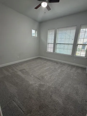 an empty room with chandelier fan