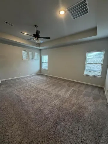 en empty room with windows and ceiling fan