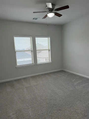 an empty room with a window and a fan