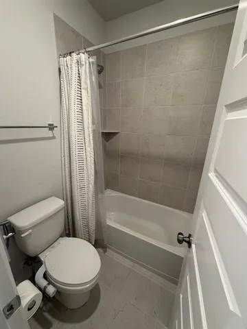a bathroom with a toilet and a shower