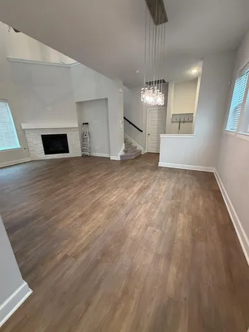 a view of an empty room with a fireplace and a window