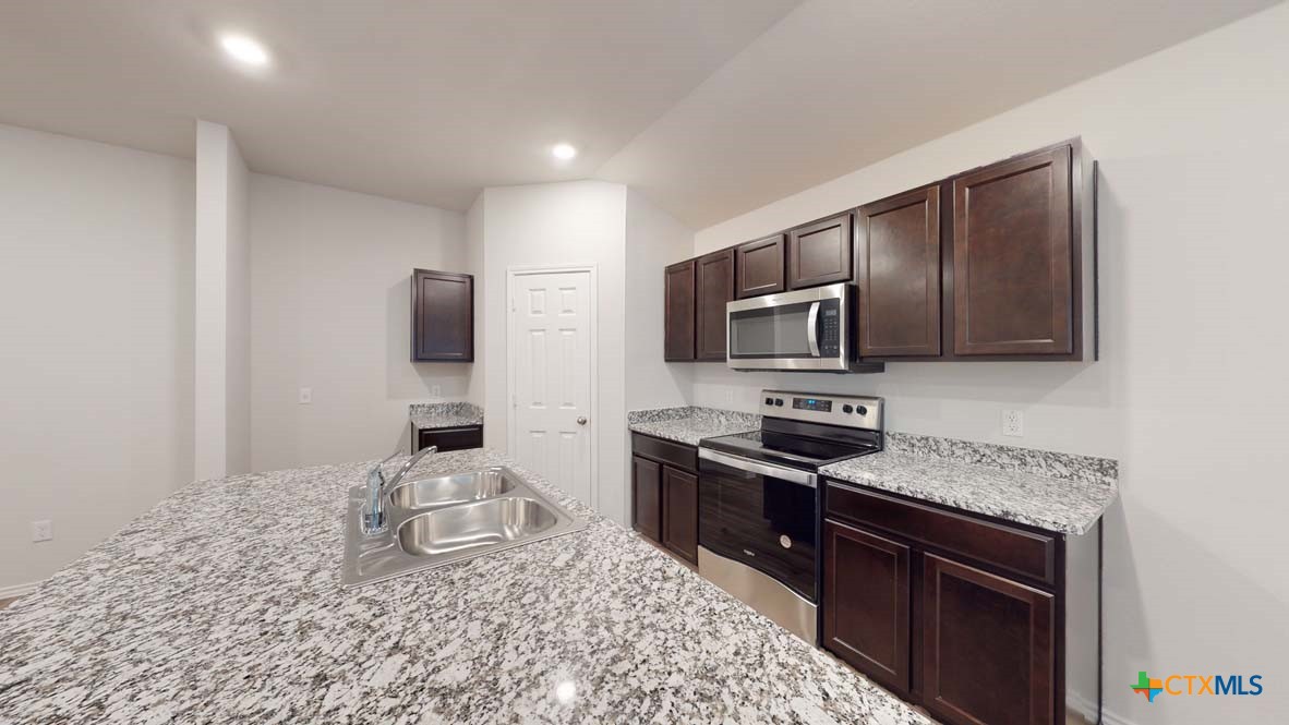 553 Hector Loop Georgetown, TX 78626 - Photo 7 of 21 a kitchen with a sink stove and microwave