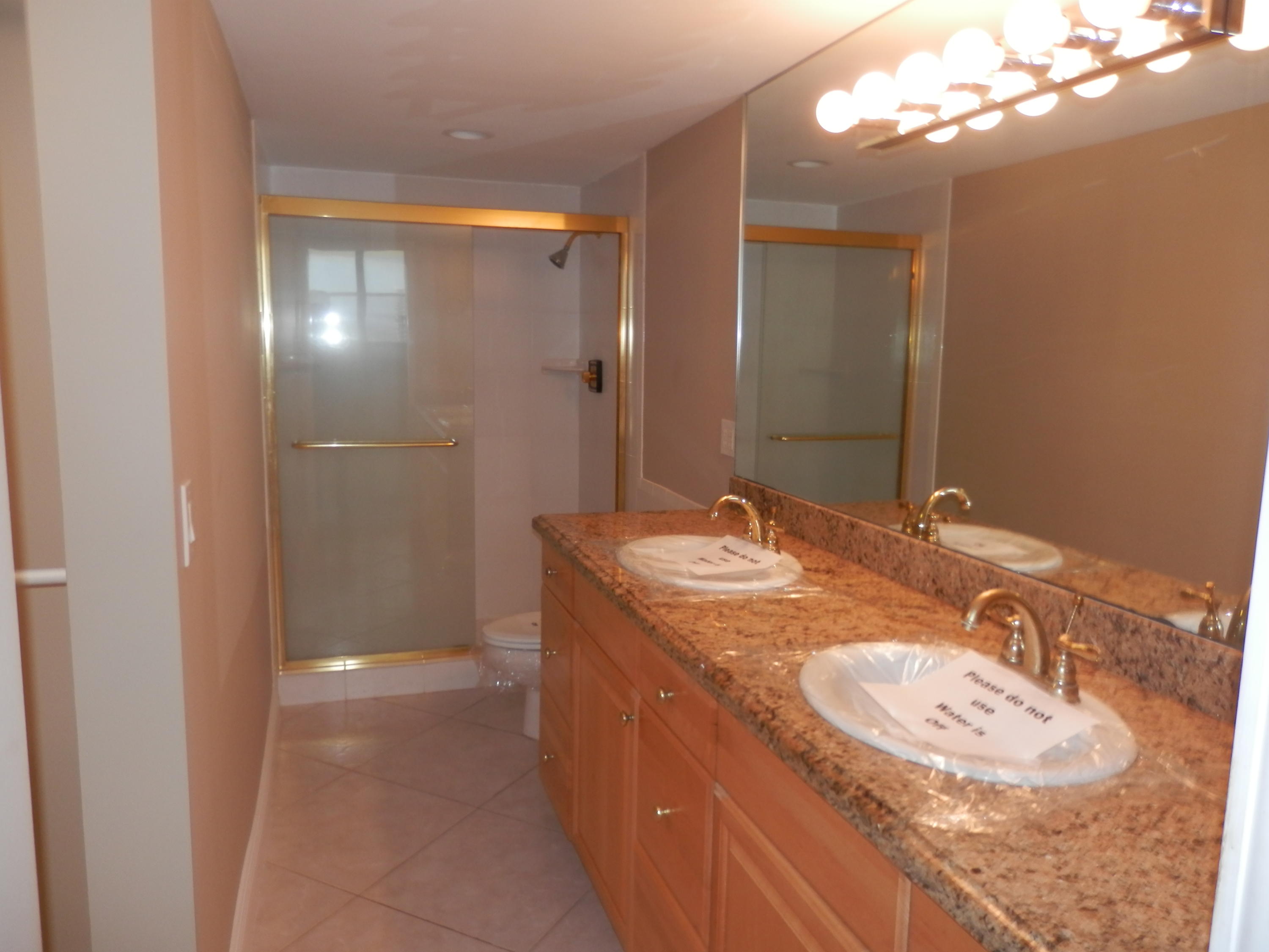 336 Golfview Road, Unit PH5 North Palm Beach, FL 33408 - Photo 7 of 11 a bathroom with a granite countertop sink a mirror and a shower