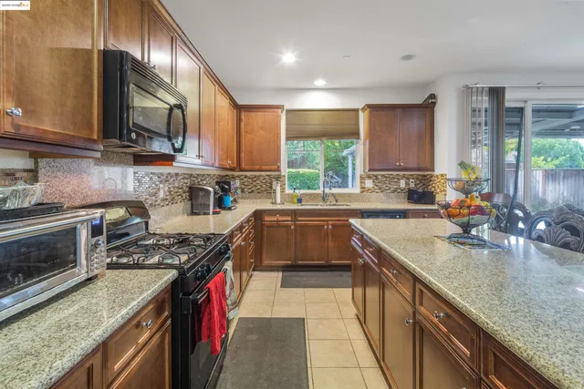 a kitchen with stainless steel appliances granite countertop sink stove top oven and cabinets