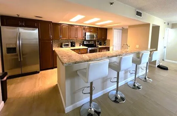 a kitchen with kitchen island granite countertop a stove and a refrigerator